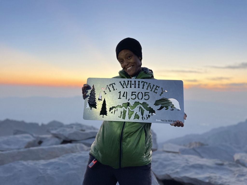 Crystal pictured smiling at the summit of Mt Whitney at sunrise