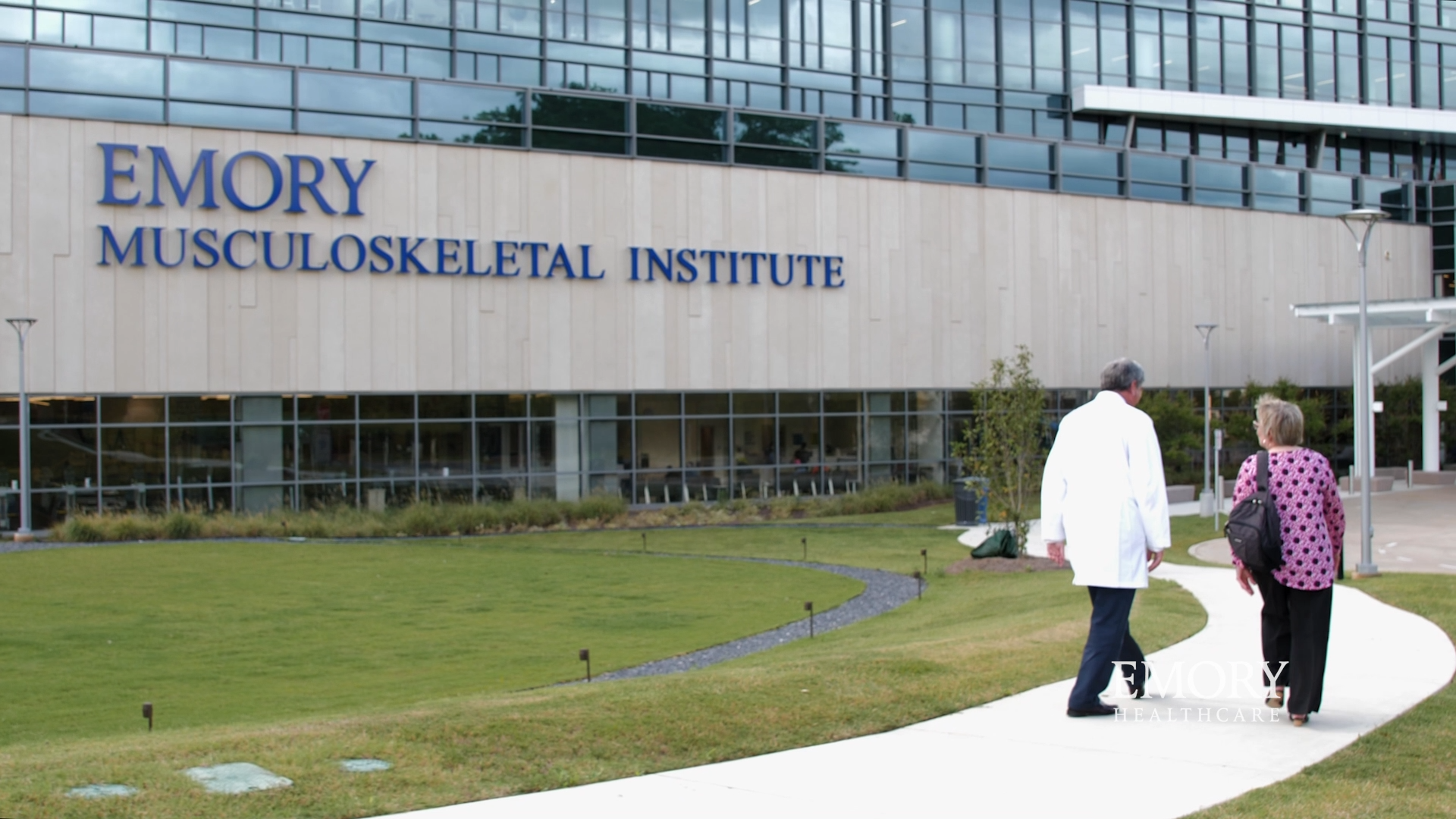 Dr Boden and Carol walking outside Emory Musculoskeletal Institute