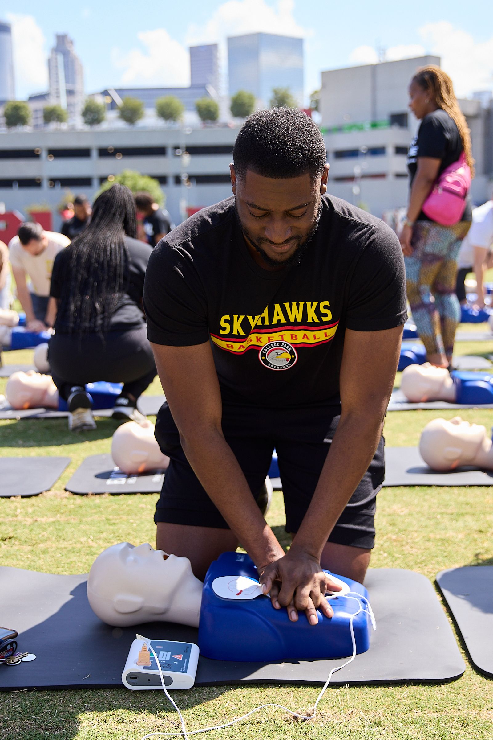man practices chest compressions on medical cpr dummy