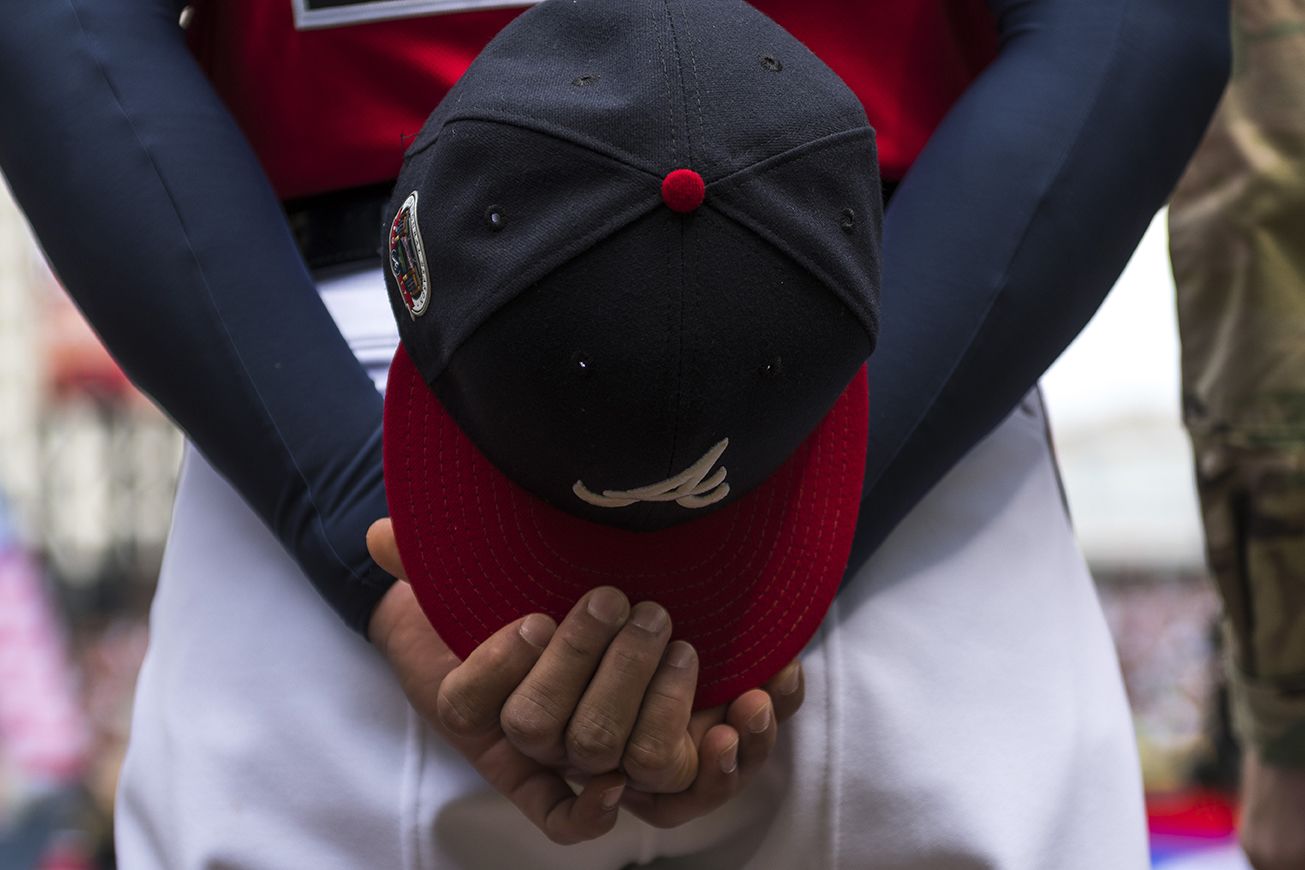 Atlanta Braves baseball cap clasped behind a player's back