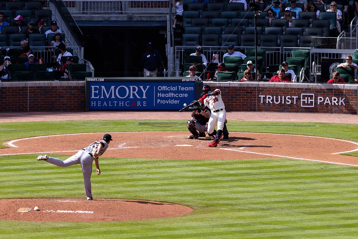 The bat connects with the ball with Braves at bat